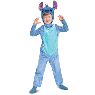 Toddler in a blue costume with character hood, resembling the Disney character Stitch, posing with one hand raised and an open mouth.