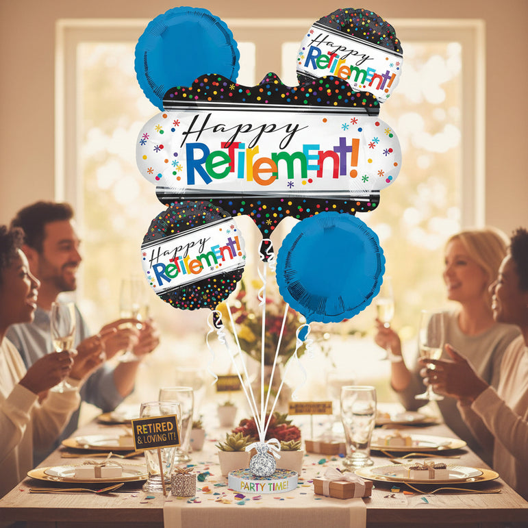 A retirement party balloon bouquet set on a dining table with people holding drinks in the background. The bouquet includes blue round balloons, black balloons with colorful confetti dots, and white banners reading 'Happy Retirement!' with multicolored text and stars.