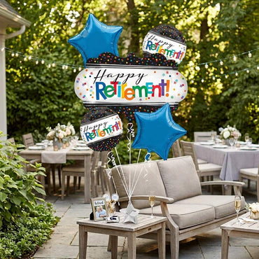 A retirement party balloon set displayed on an outdoor patio. The set includes three blue star-shaped foil balloons, three black balloons with colorful confetti patterns, and a large white banner balloon that reads 'Happy Retirement!' in multicolored letters.