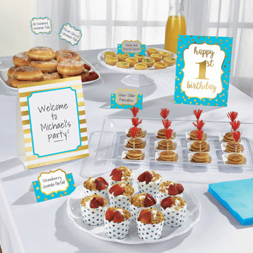 Table with party food and decorations for a first birthday celebration.