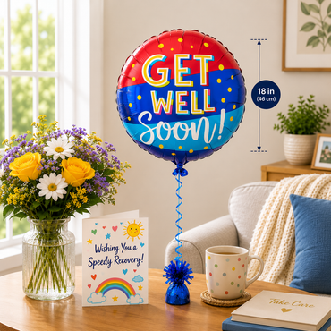 A round foil balloon reading “GET WELL Soon!” in red, white, and blue with yellow polka dots, displayed in a bright living room setting next to a flower vase, greeting card, mug, and pillow. A vertical measurement marker indicates the balloon is 18 in (46 cm) tall.