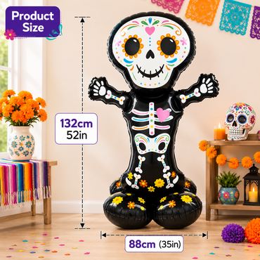 A large black inflatable skeleton balloon decorated with colorful Day of the Dead style face and body details, shown in a decorated room with size callouts reading 132cm (52in) tall and 88cm (35in) wide. Product size labels and decorative flowers, candles, and papel picado hang around it.