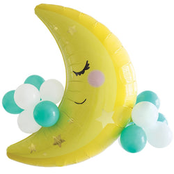 A yellow crescent-shaped balloon with a face accented with smaller balloons in blue, green, and white.