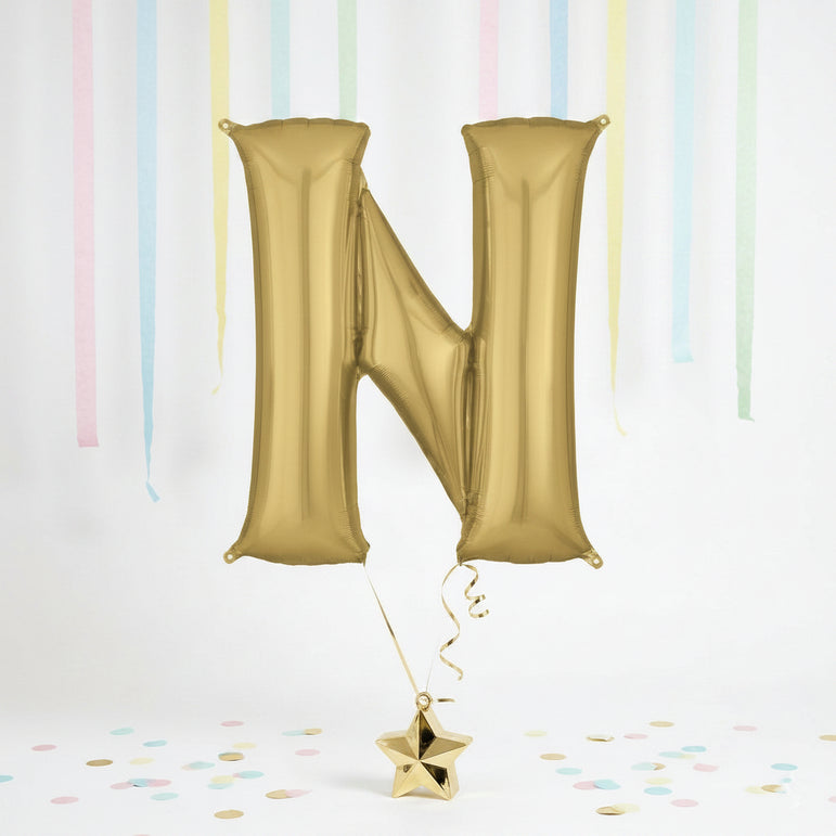 Gold letter 'N' balloon with a star-shaped confetti on a light background