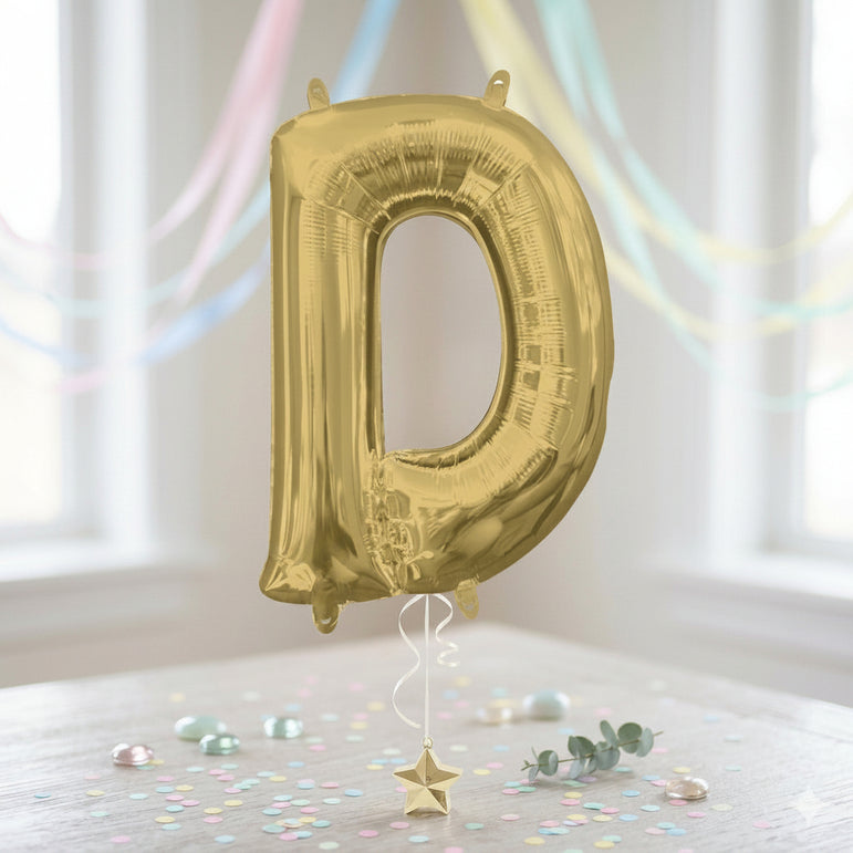 Gold letter 'D' balloon against a white background with colorful ribbons and confetti.