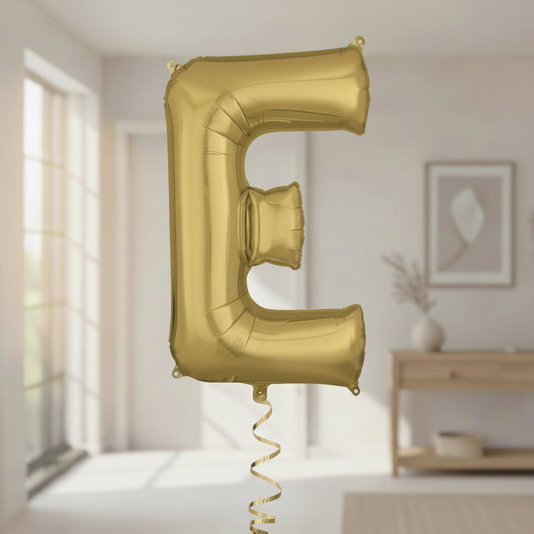 Gold letter 'E' balloon in a room with a blurred background