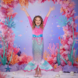 Child wearing a mermaid costume with pink and blue tail on a white background