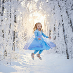 Child wearing a blue dress with a cape and tiara on a white background