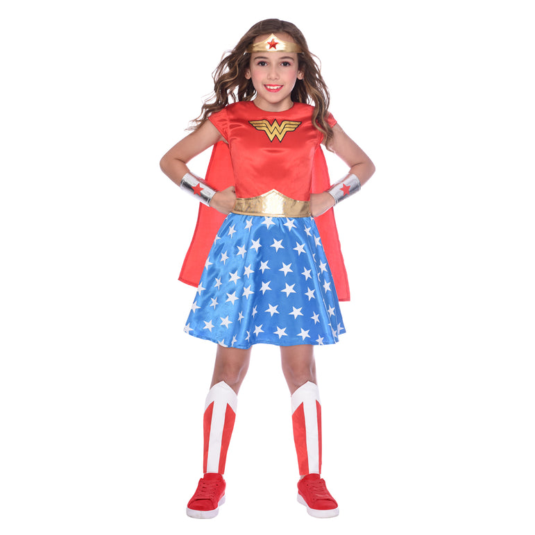 A girl dressed in a Child Wonder Woman Classic Costume with a red dress, blue skirt with white stars, white leg covers, red shoes, and a gold headband with the Wonder Woman logo.