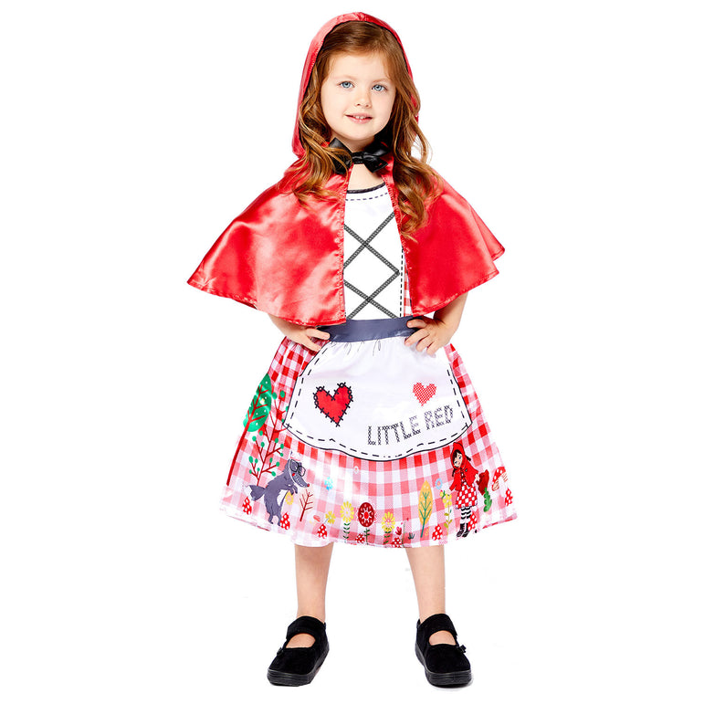 Child wearing Little Red Riding Hood costume with red cape and apron dress, hands on hips.